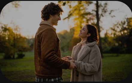 A couple holding hands outdoors in autumn.